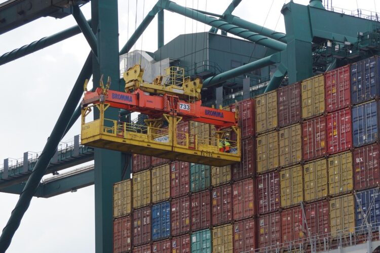 Containerkraan verplaatst zeecontainers in haven, cruciaal voor klantbeleving in logistiek.