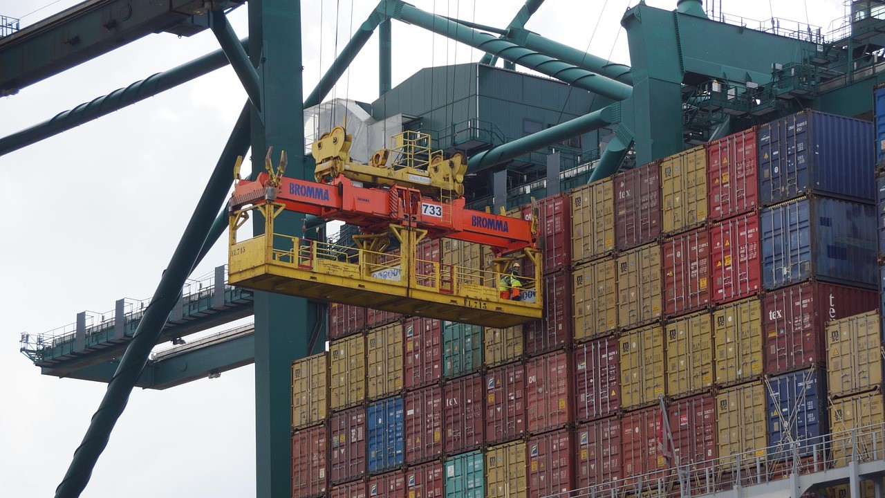 Containerkraan verplaatst zeecontainers in haven, cruciaal voor klantbeleving in logistiek.