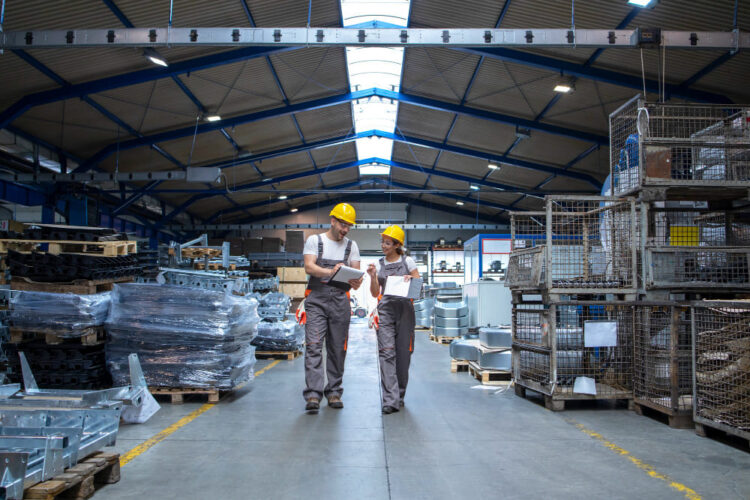 2 mensen lopen door een magazijn heen.