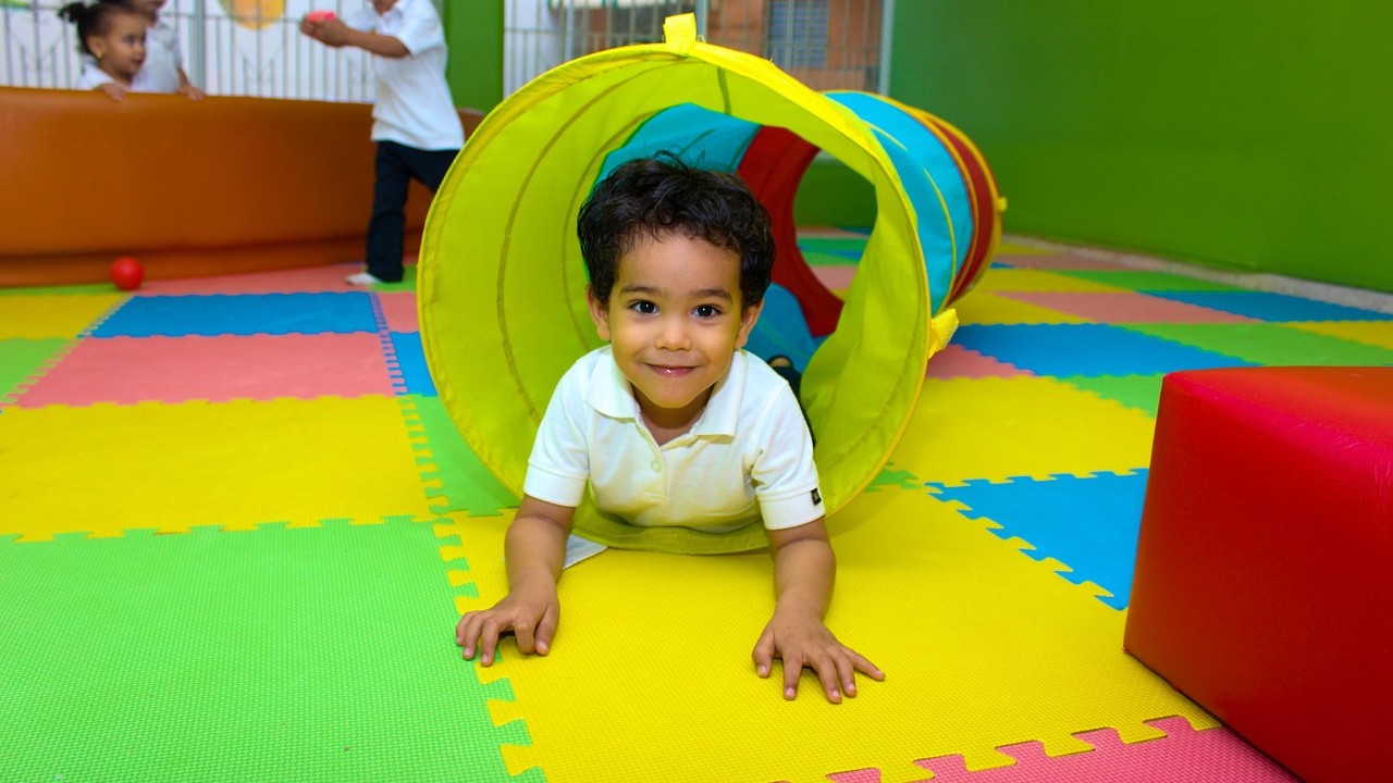Kind speelt in kleurrijke kinderopvang, ideaal voor ouders met onregelmatige werktijden