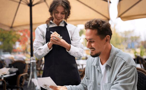 man op terras met ober