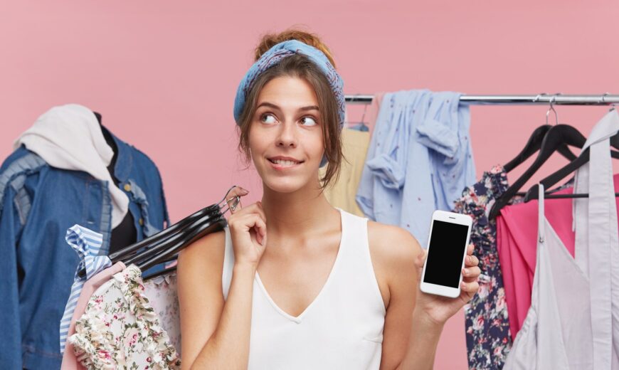 vrouw met kleding en telefoon in haar handen