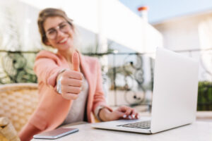 blije mevrouw voor een laptop