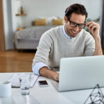 tevreden makelaar achter een laptop