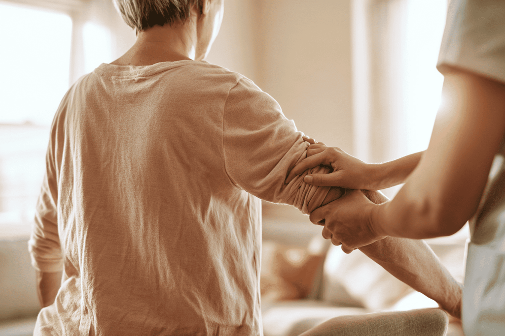 Therapeut heeft de arm van een persoon vast in de woonkamer